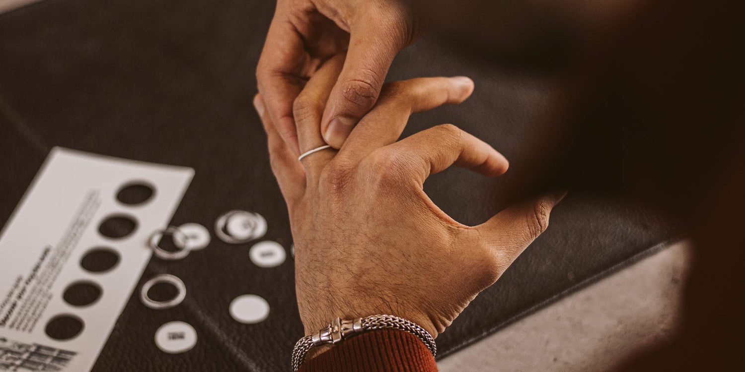 A man using ring size chart to measure the ring size