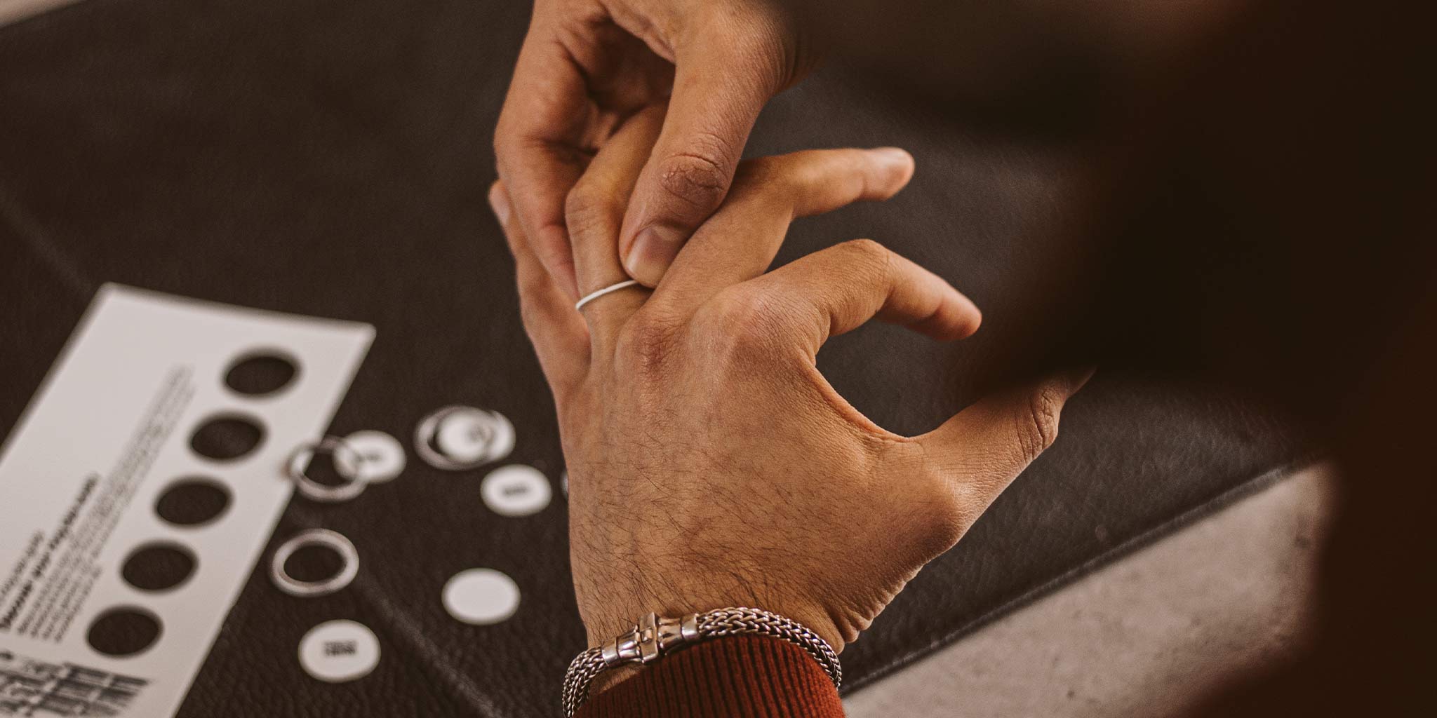 A man using ring size chart to measure the ring size