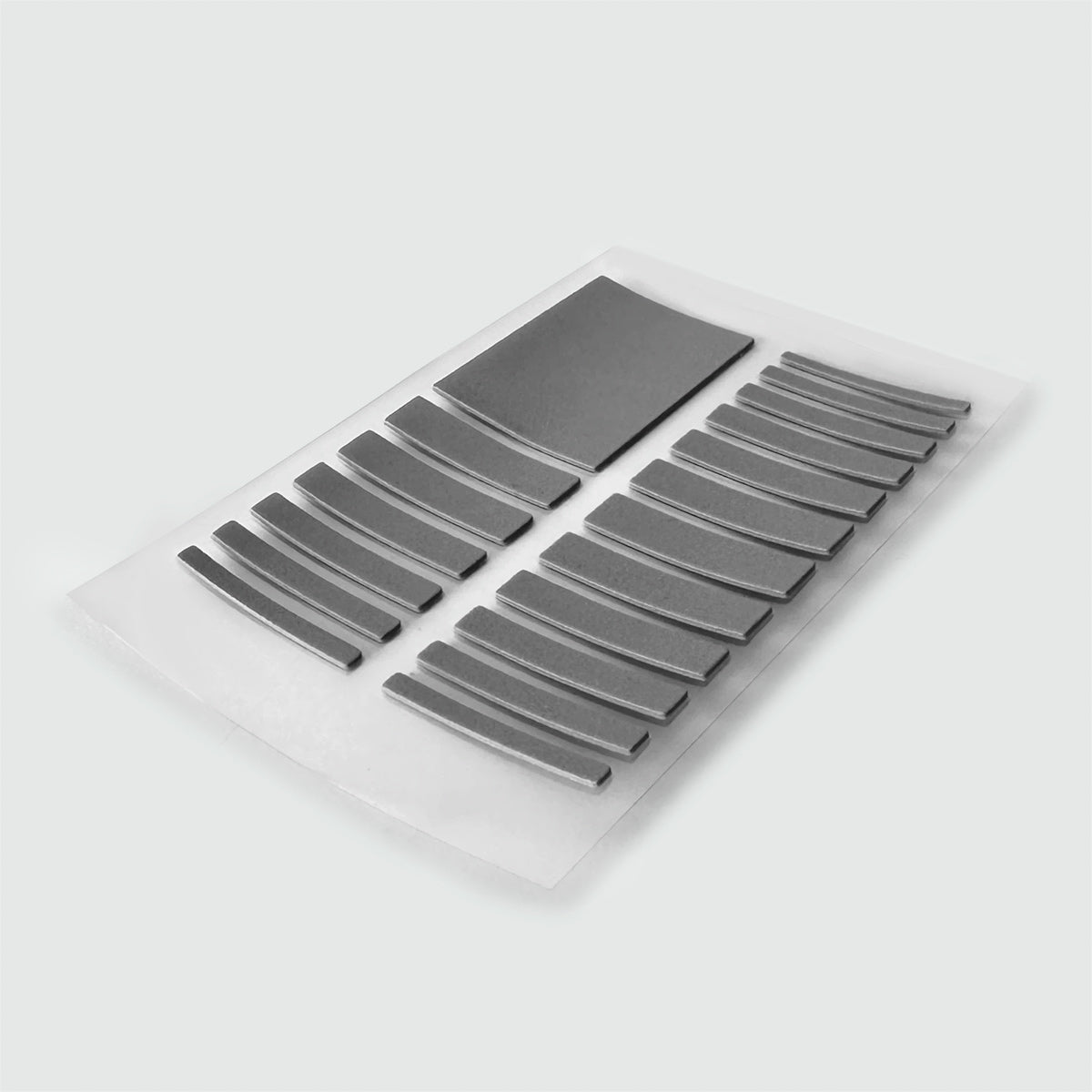 A set of metal strips, including a Ring Size Adjuster, on a white surface.