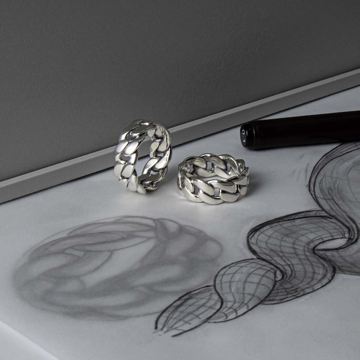 Two silver rings on a piece of paper and a sketch
