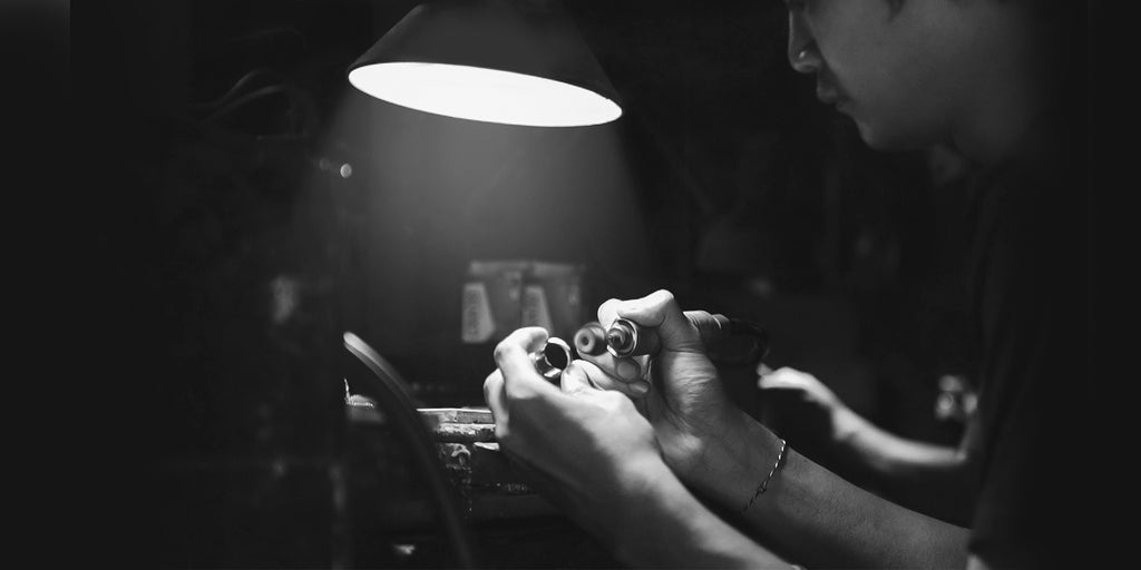 A photo of a man working on a watch.