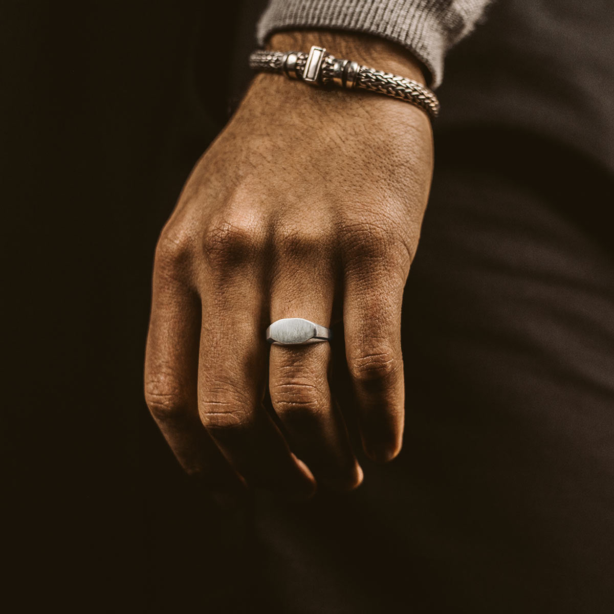 Een man draagt een aanslagvrije zilveren ring en armband