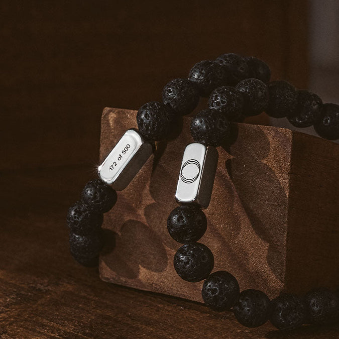 Black lava stone free men's bracelets from Ninetwofive on a wood brick.