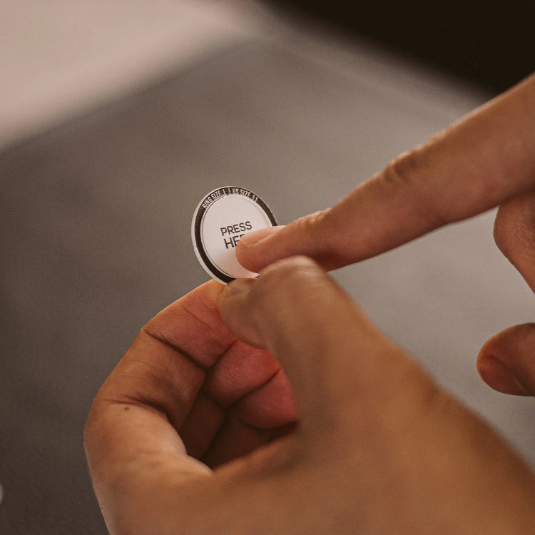 A person applying a sticker on a piece of paper.