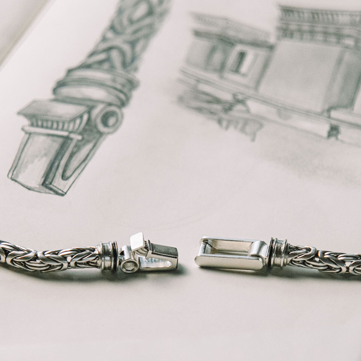 A pair of silver bracelets on a piece of paper.
