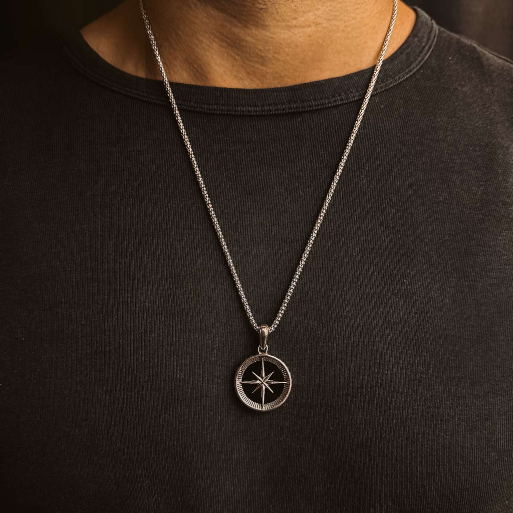 A man wearing a Safar - Sterling Silver Onyx Compass Pendant necklace.