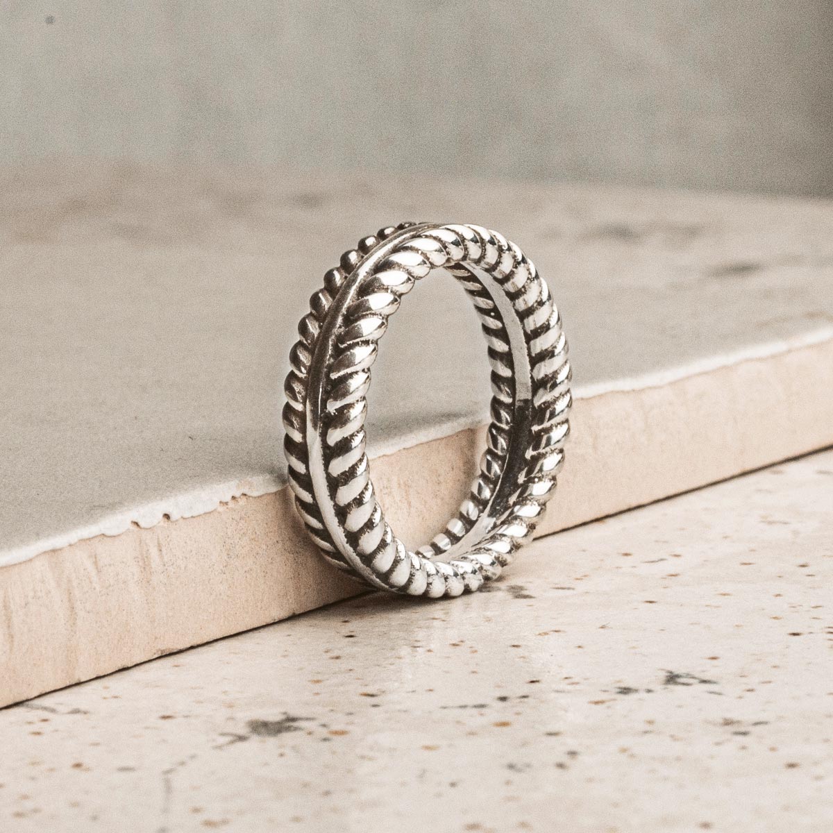 Ein silberner Ring, der auf einem Stück Papier ruht.