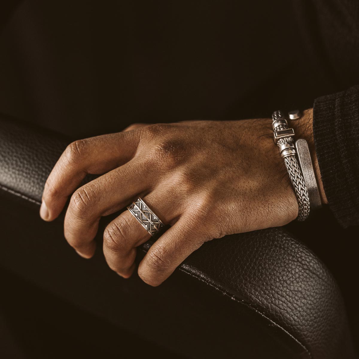 Model trägt einen silbernen Herrenring und ein Armband von ninetwofive