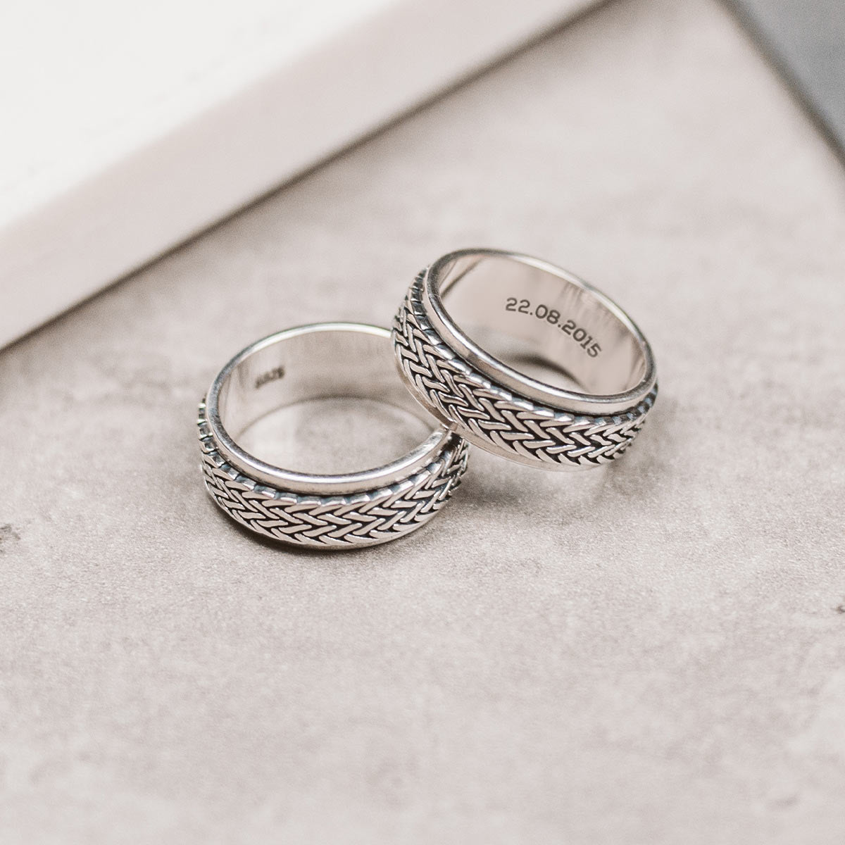 Two silver rings on a table.