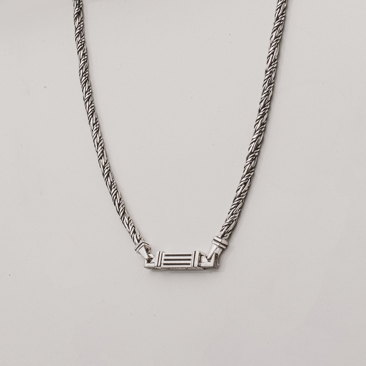 Een zilveren ketting met een hanger.