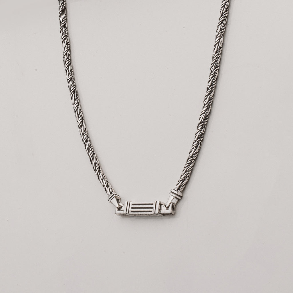A silver chain necklace with a pendant.