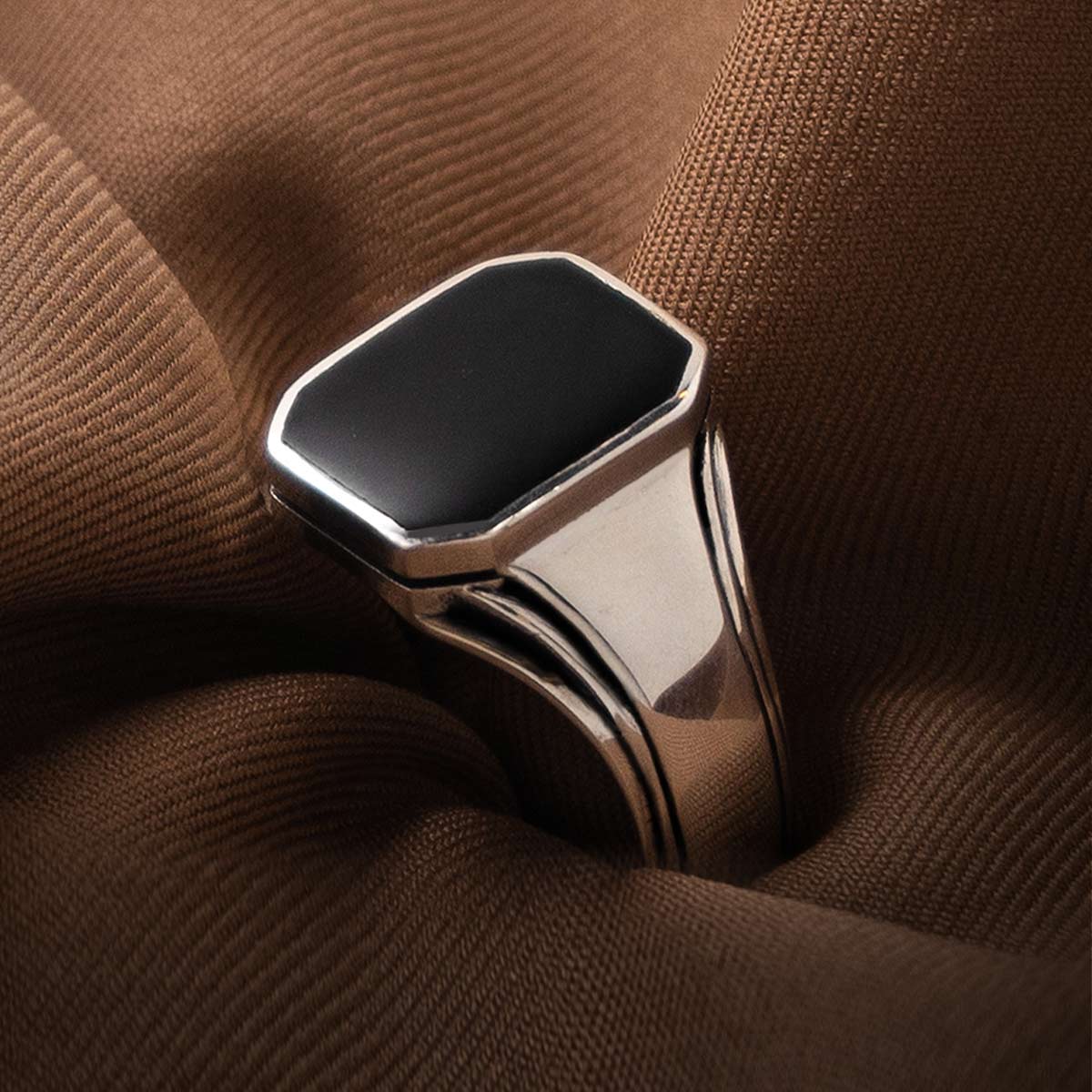 A silver ring with a black onyx stone.