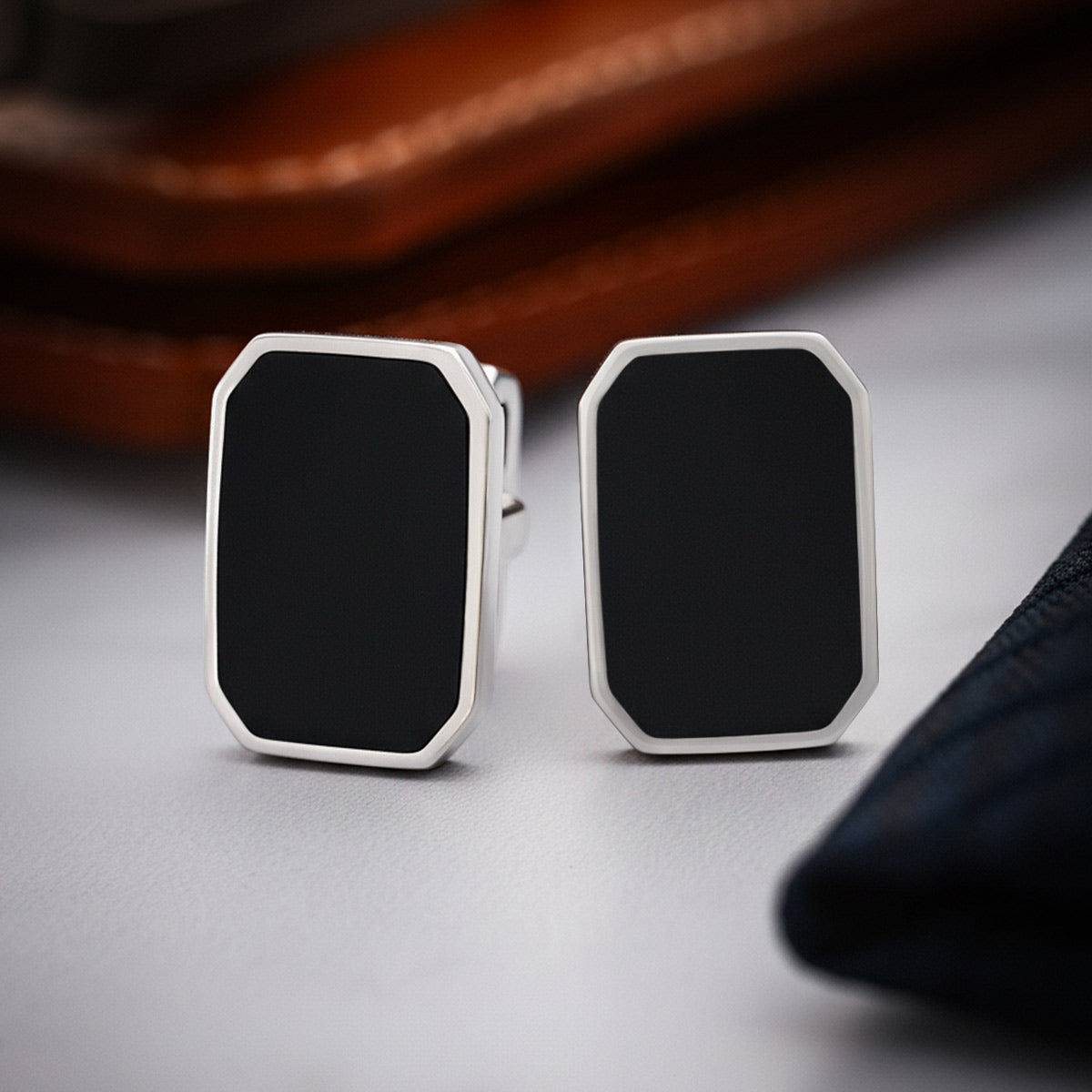 Rael 925 zilveren Black Onyx heren manchetknopen van Ninetwofive met een bruine portemonnee opzij.