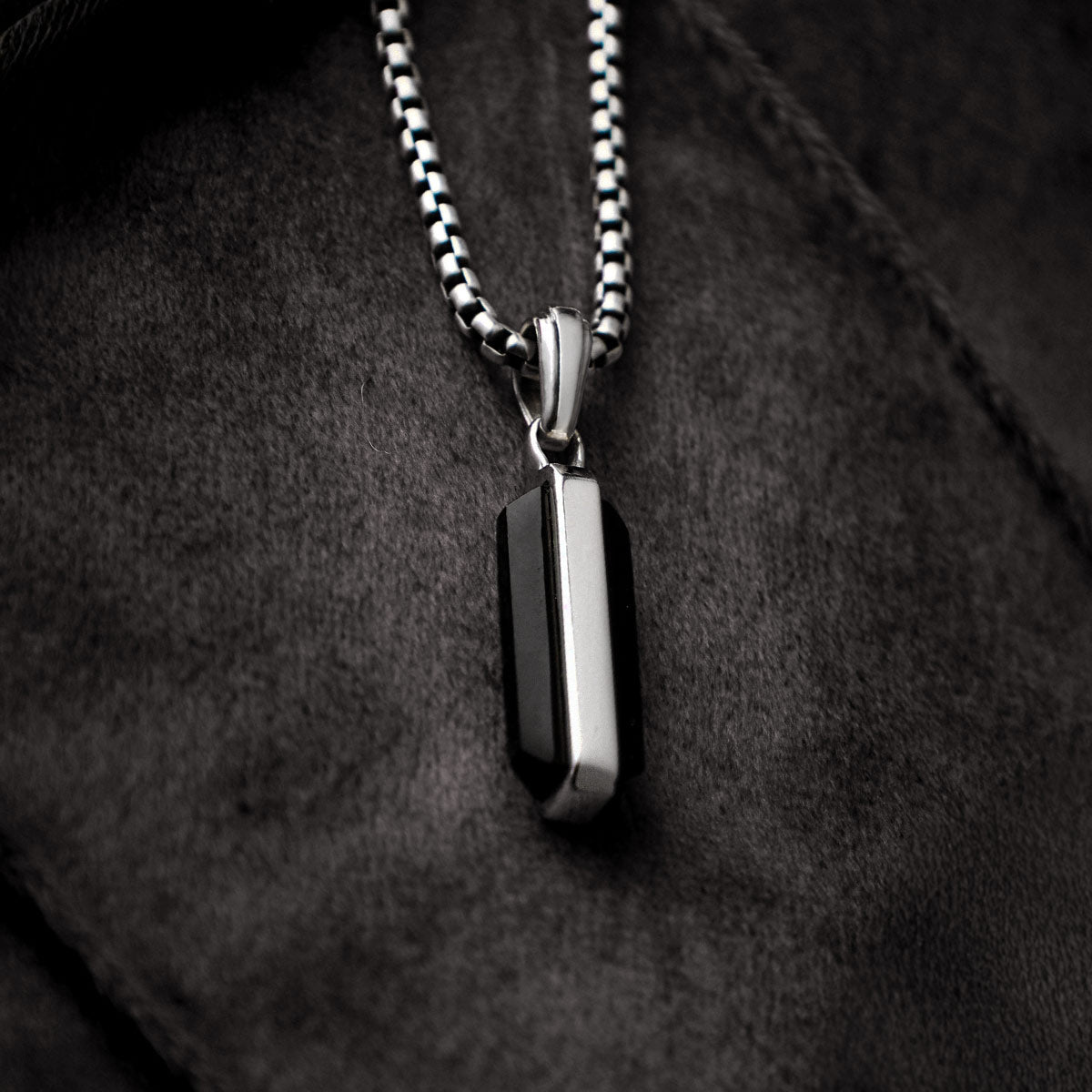 Samir black onyx sterling silver pendant for men displayed on black paper from Ninetwofive