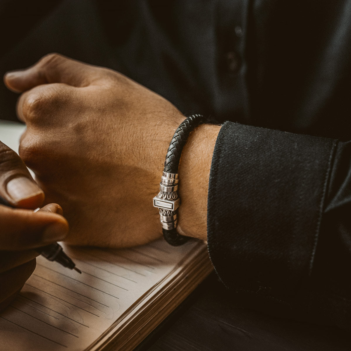 A model wearing leather and silver combination bracelet for men from ninetwofive