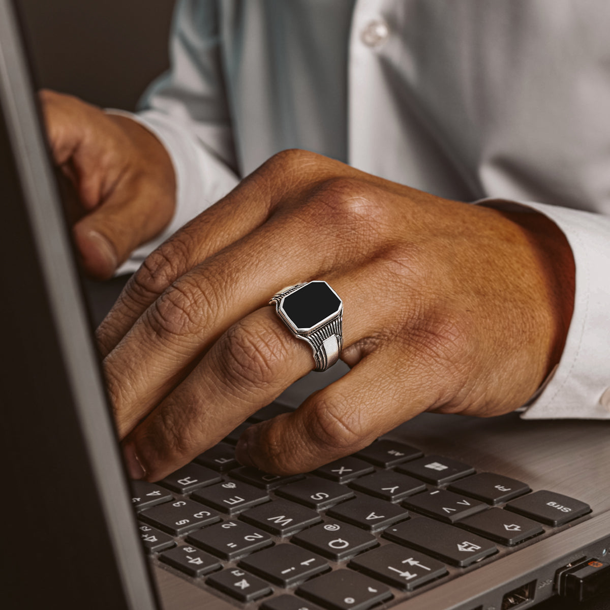 Silver rings for men featuring black onyx worn on the wedding finger