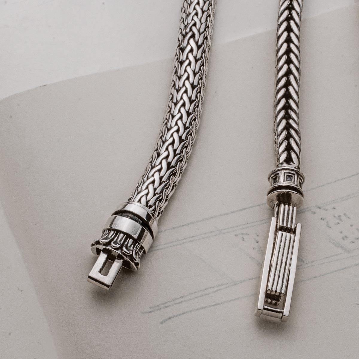 Two silver bracelets on top of a piece of paper.