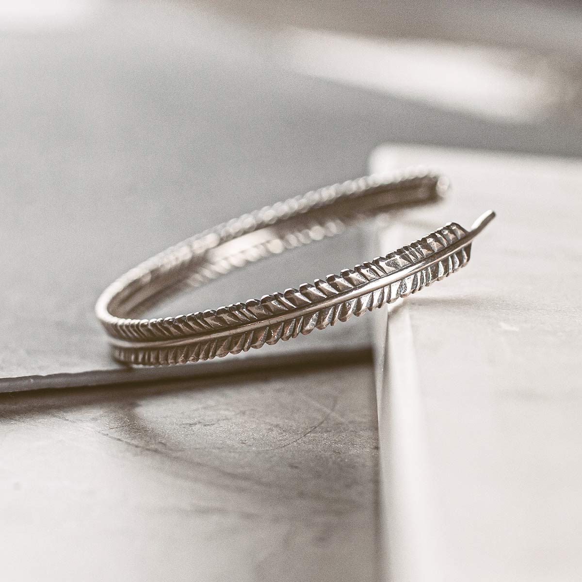 Une paire de boucles d'oreilles en argent sur une table.