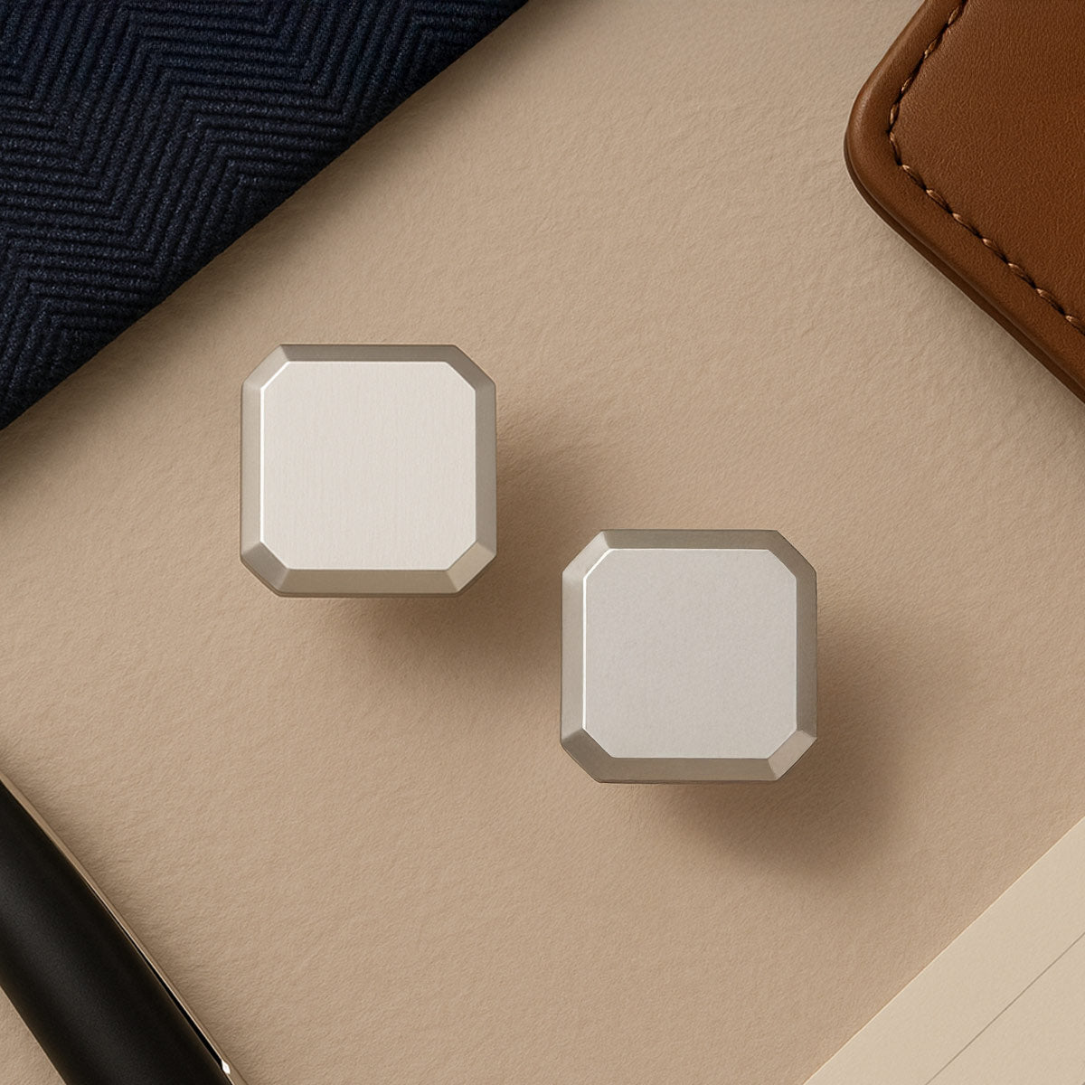 Hayel sterling silver matt finish men’s cufflinks from Ninetwofive with a pen and brown wallet background.