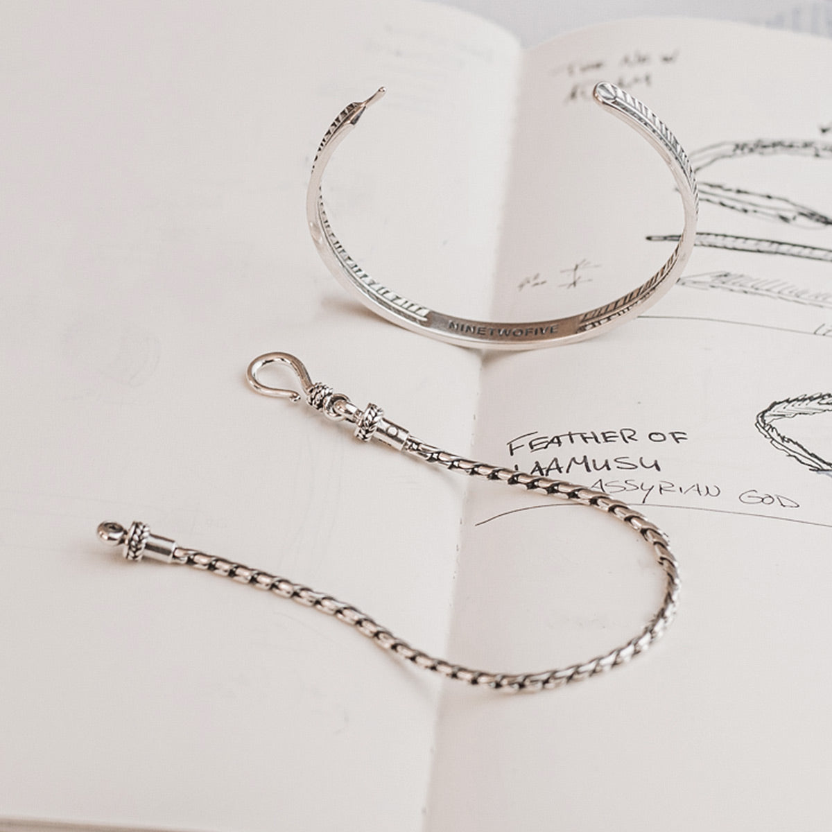 Een paar oorbellen en een armband op een opengeslagen boek.
