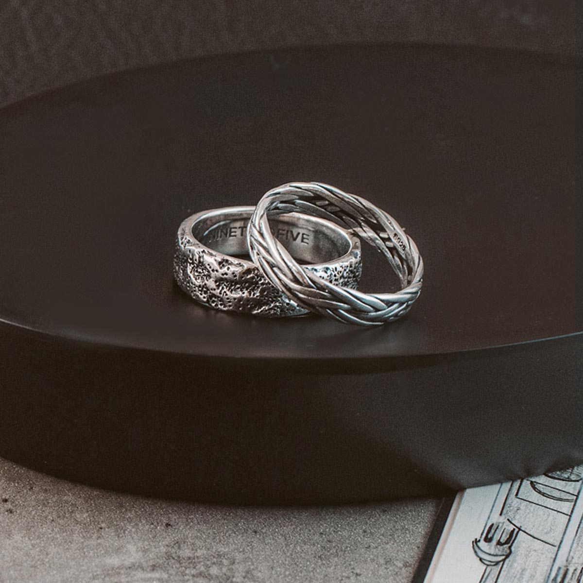 Two silver rings sitting on top of a plate.