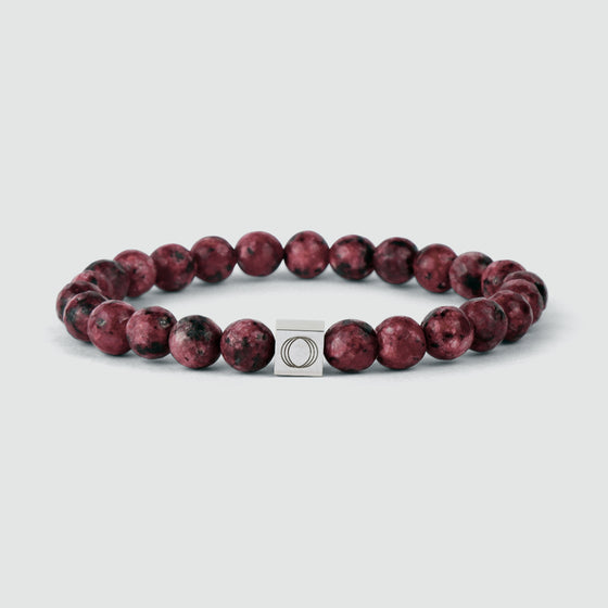 Ahmar men's red beaded bracelet, featuring a silver square charm engraved with the Ninetwofive logo.