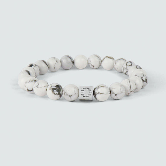 Front view of the Alrukham mens beaded bracelet with detailed look of white marble and engraved Ninetwofive logo.
