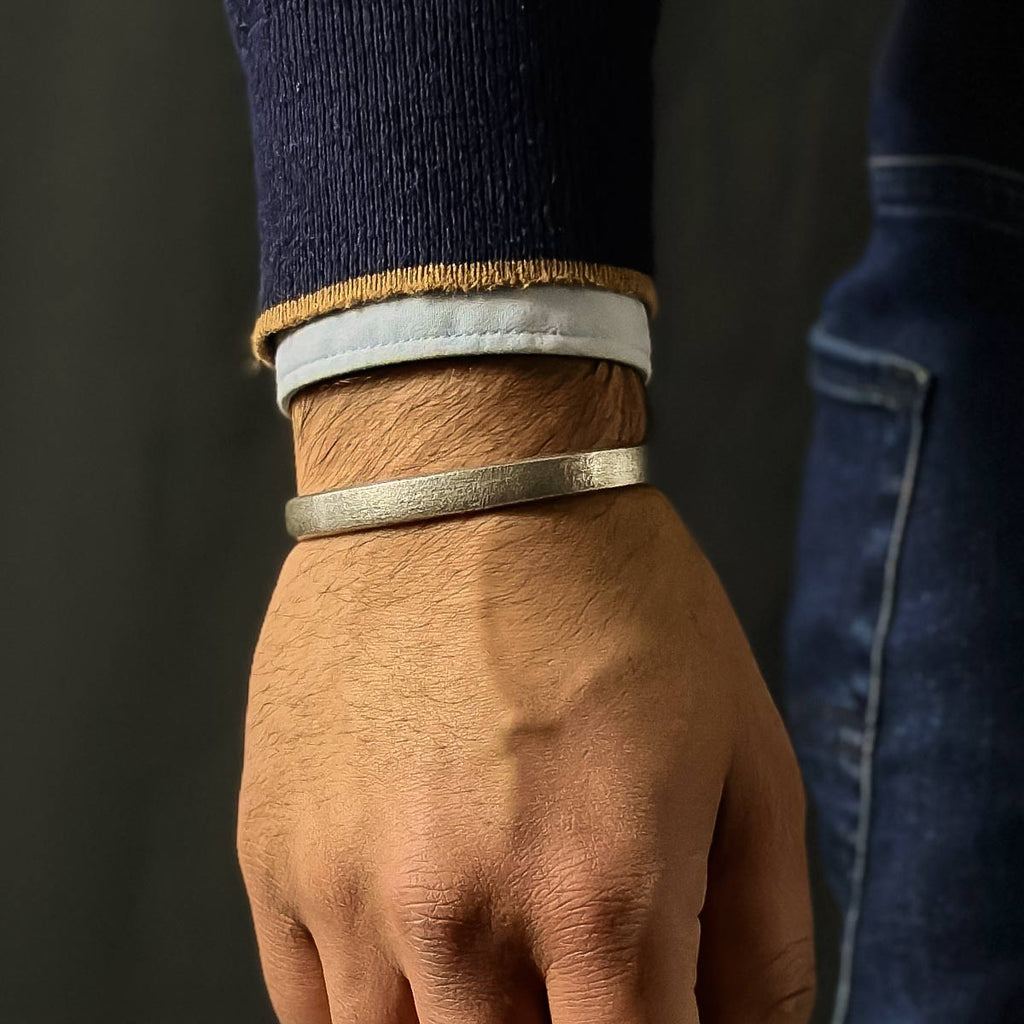 A man wearing a Fudail - Rough Brushed Sterling Silver Bangle 8mm.