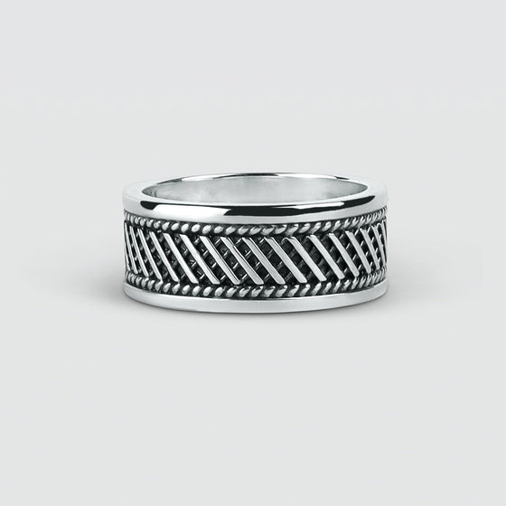Une bague homme Kaliq en argent sterling oxydé, gravée et ornée d'un motif noir et blanc.