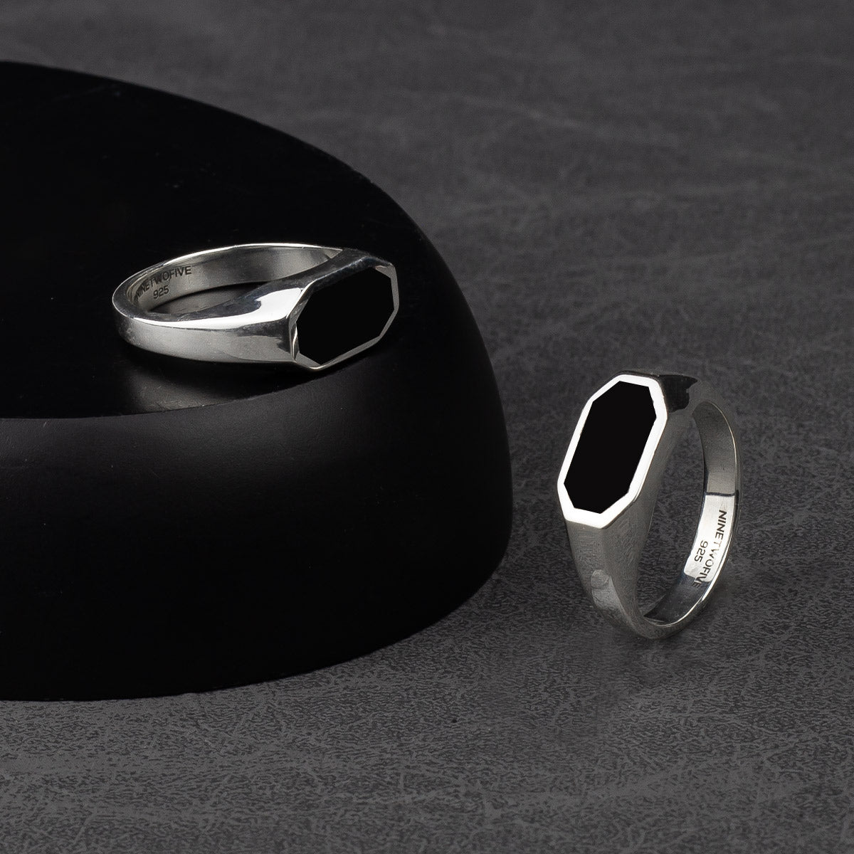 A silver signet ring with black onyx.