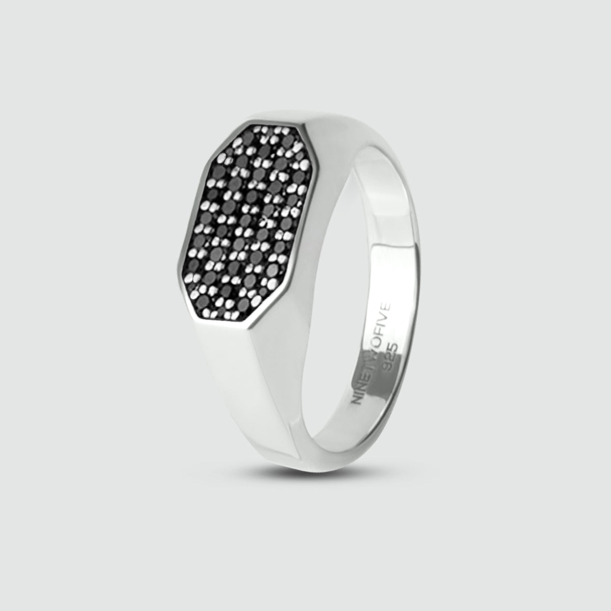 Mens silver signet ring with black diamond on a light gray background