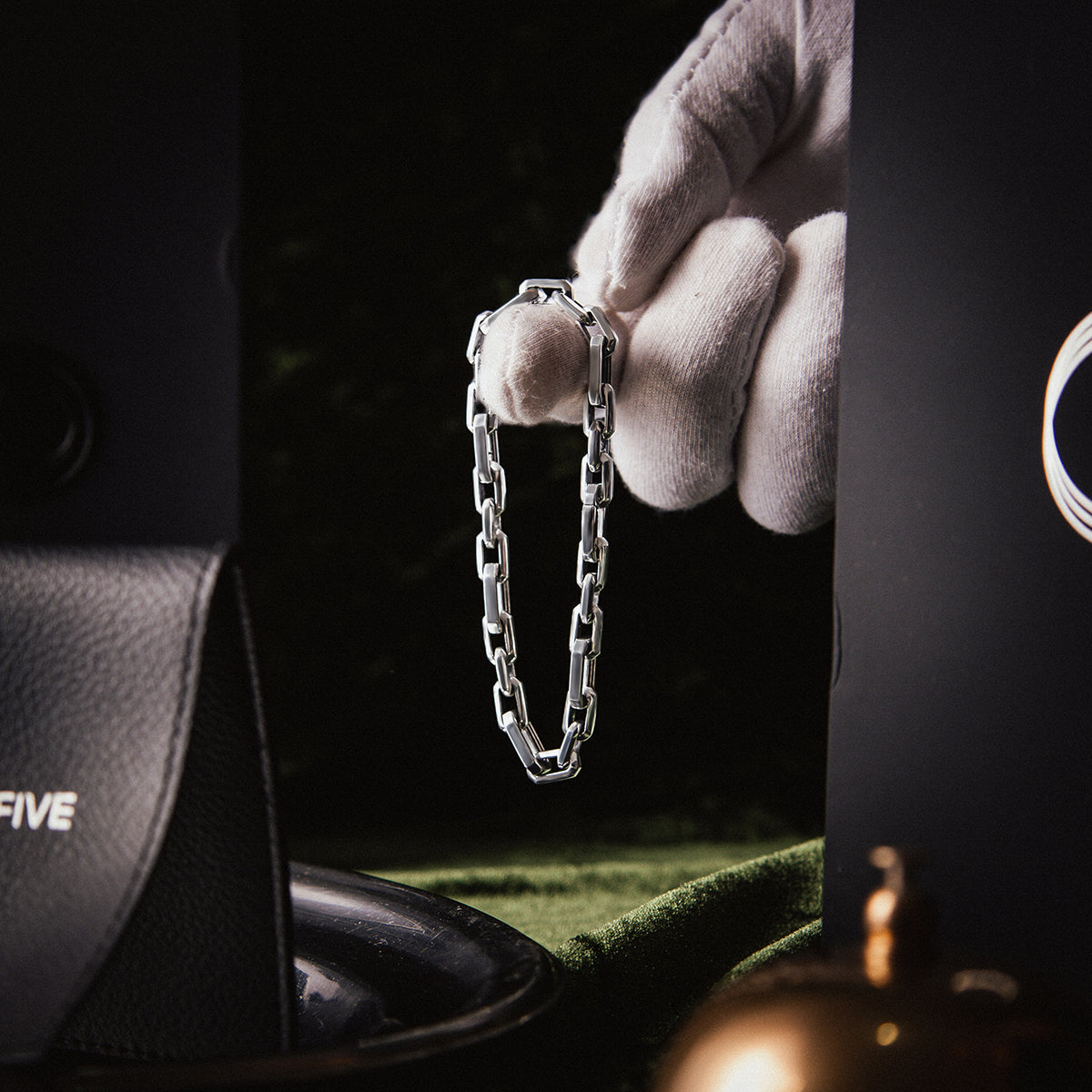 Hand, die ein 925er Silberarmband für Männer hält, um echtes Silber zu überprüfen