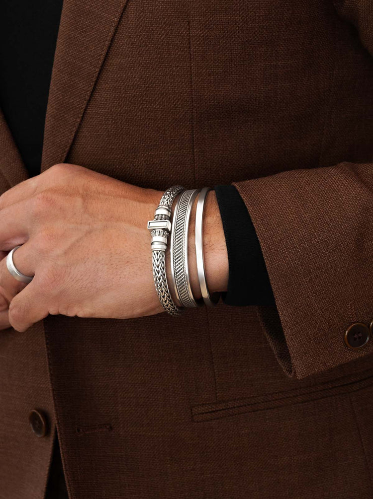 Man in a suit wearing 925 silver mens rings and byzantine bracelets from Ninetwofive.