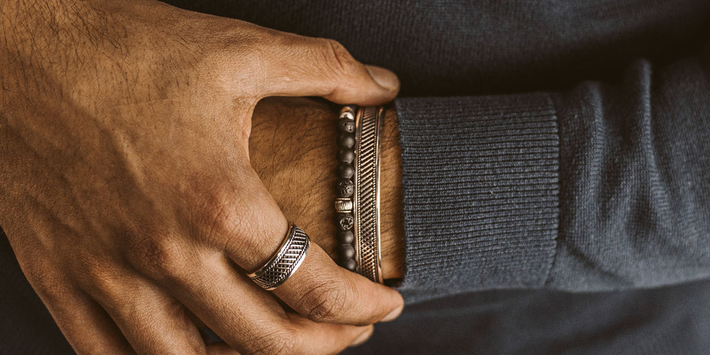 Ein Mann trägt einen Ring an seinem Handgelenk.