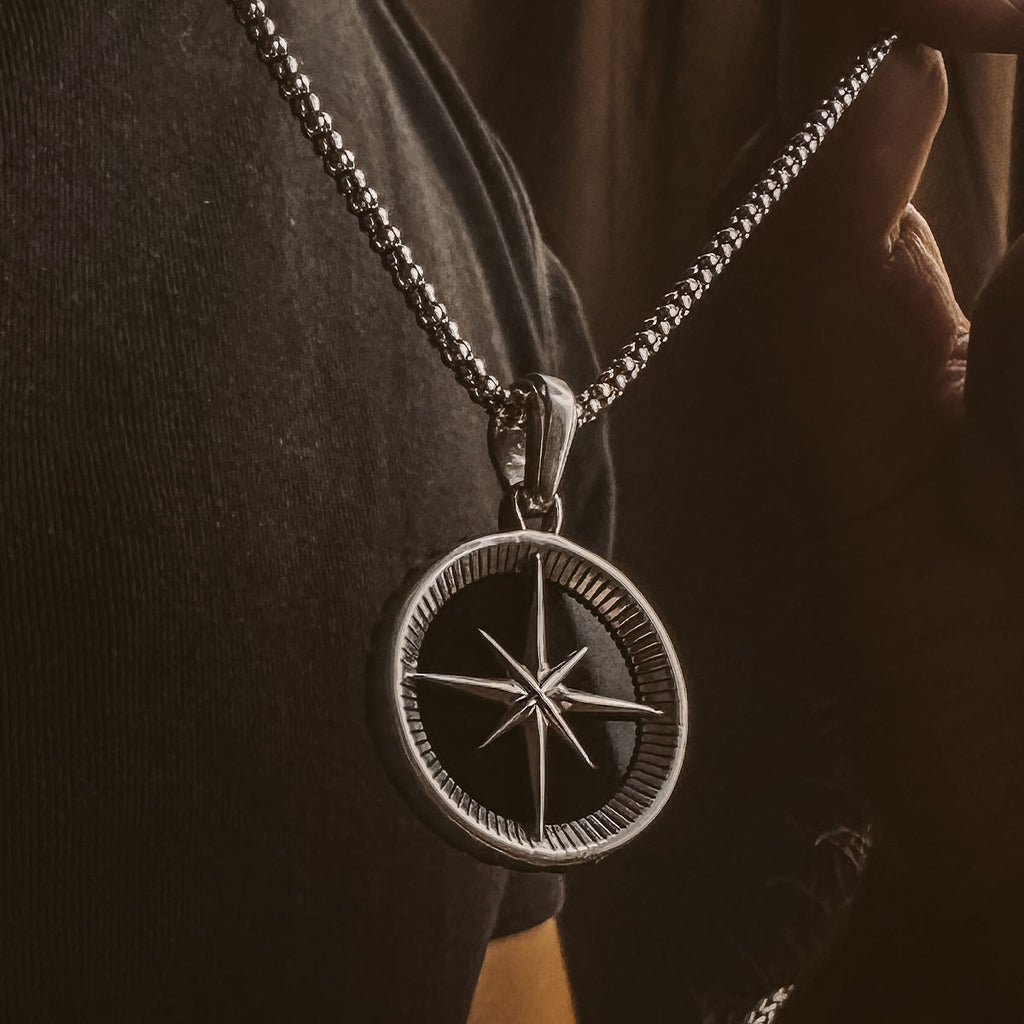 A person wearing a Safar - Sterling Silver Onyx Compass Pendant.