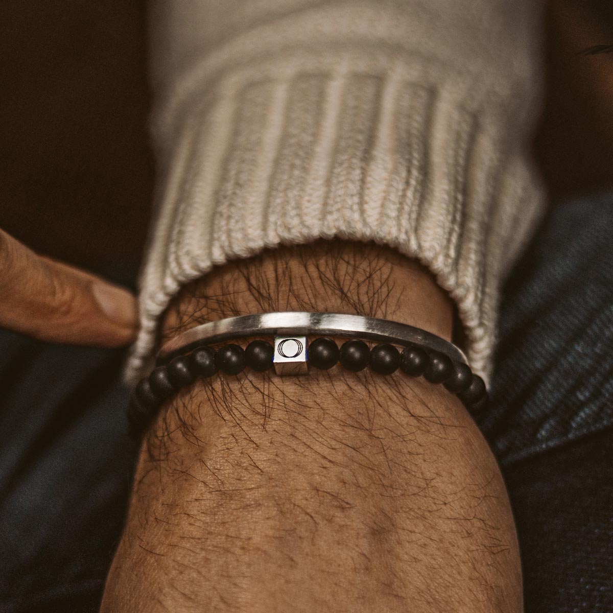 Ein Mann trägt das Aswad - Matt Black Beaded Bracelet 6mm.