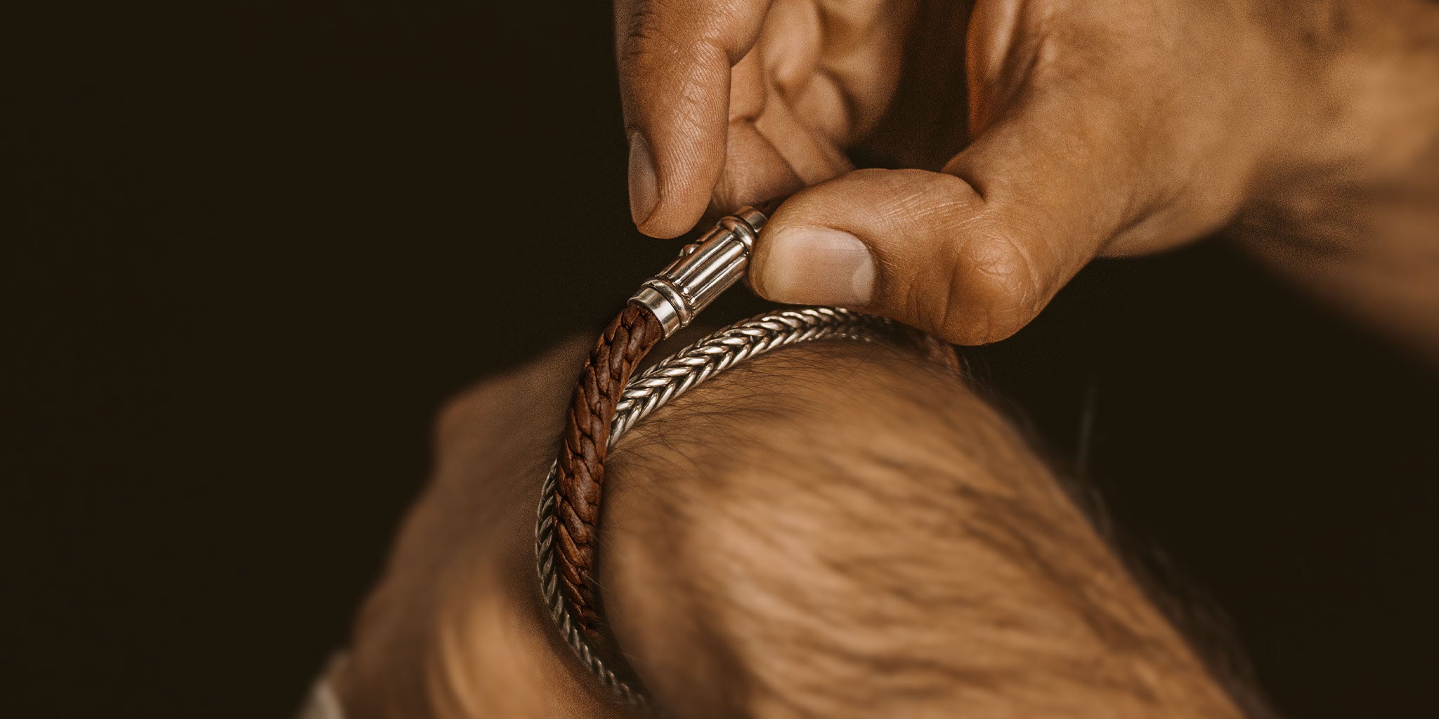 Een man doet een armband om zijn pols.