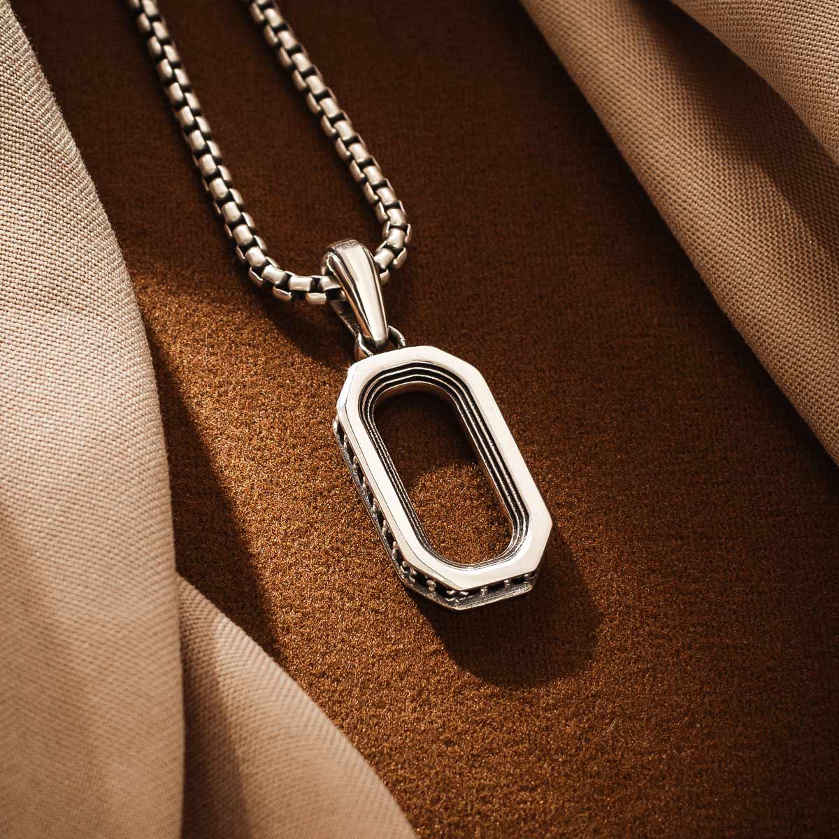 Angle supérieur du pendentif Durwās mettant en évidence le design symétrique de l'arc. Ninetwofive