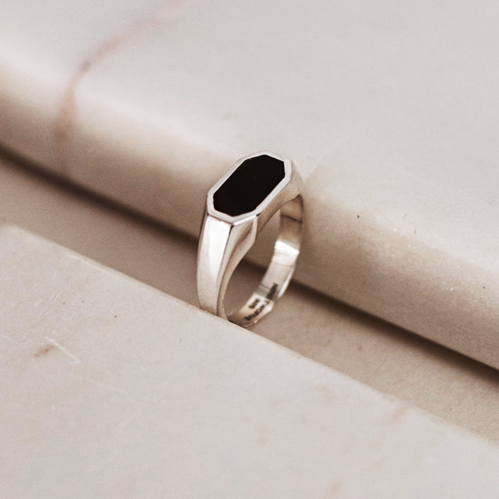 A silver ring with a black onyx stone, perfect for any occasion.