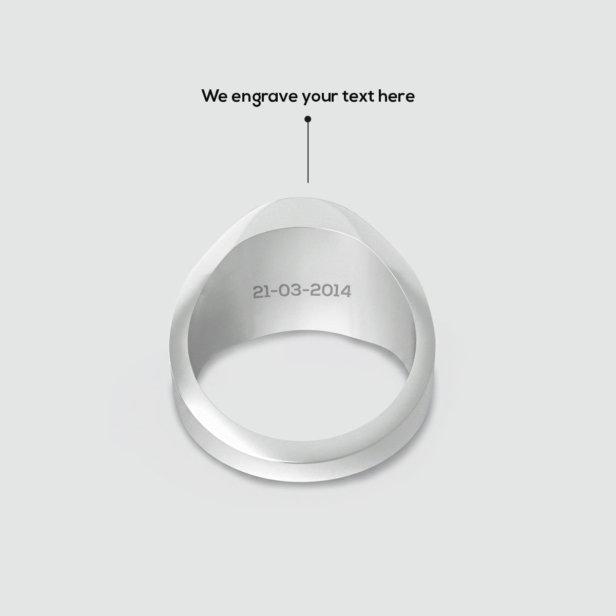 Zilveren ring met gegraveerde datum op een lichtgrijze achtergrond