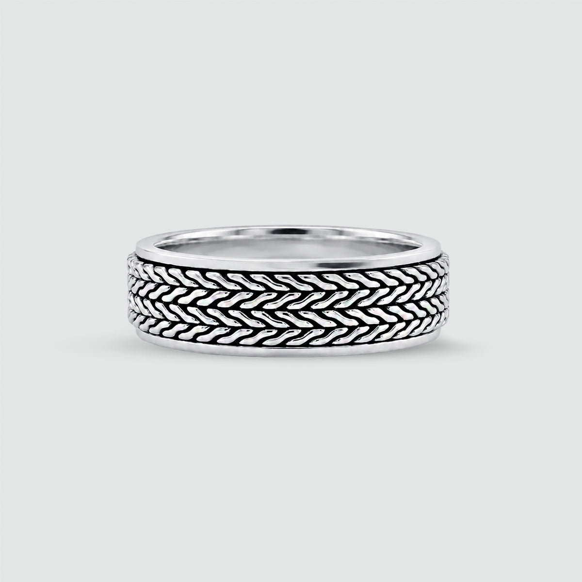 A sterling mens silver ring with a textured, woven basket-like pattern on the outer band, shown on a light gray background. 