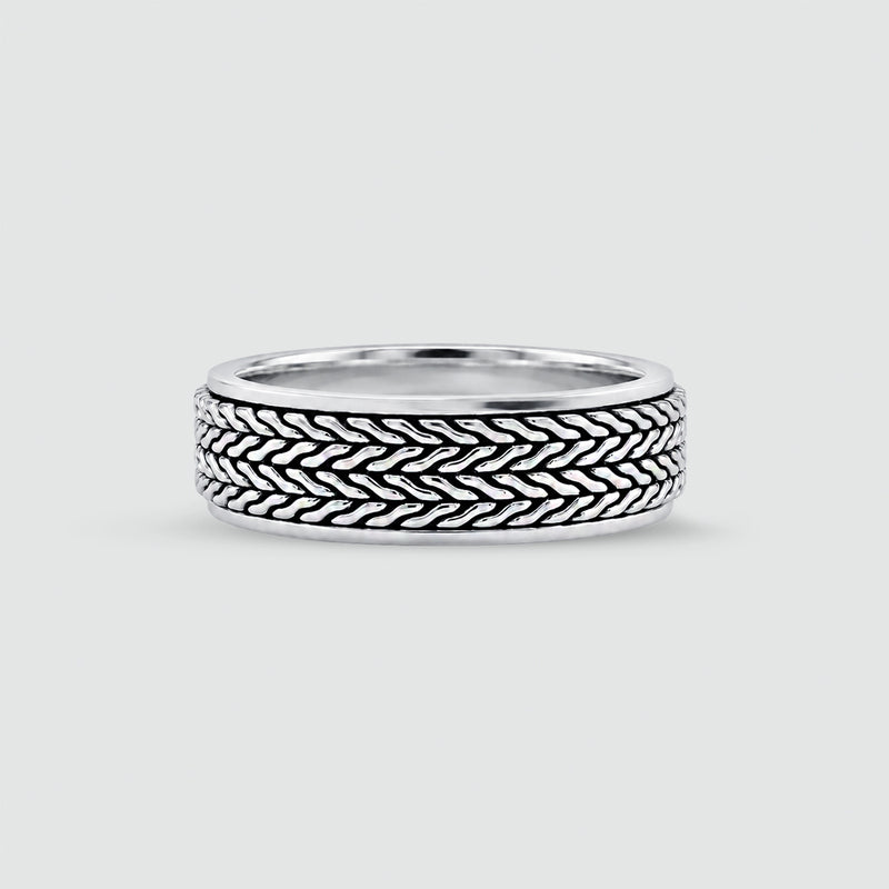 A sterling mens silver ring with a textured, woven basket-like pattern on the outer band, shown on a light gray background. 