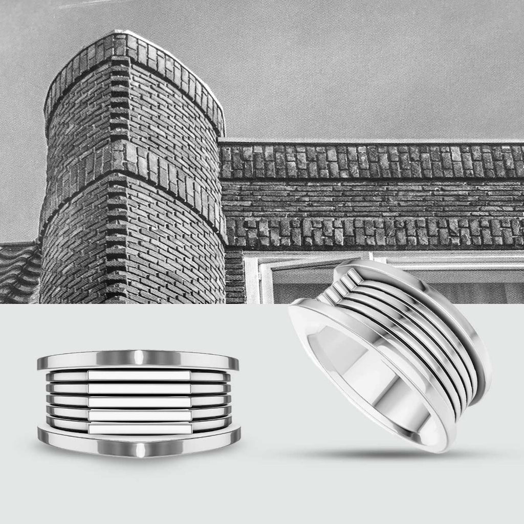A black and white photo of a building and a silver ring.