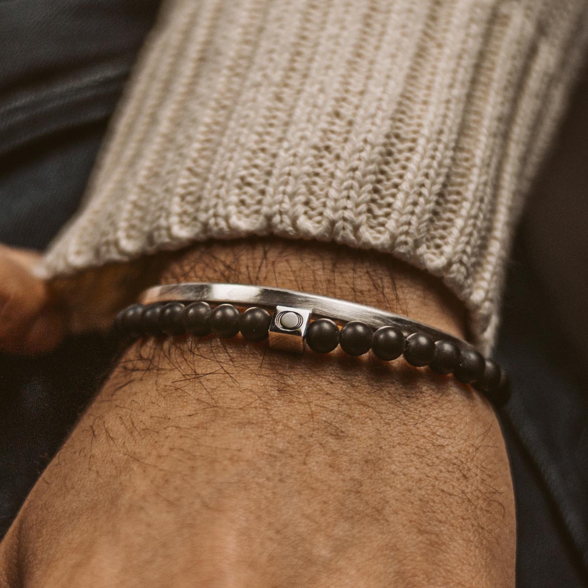 Ein Mann trägt ein Aswad - Matt Black Beaded Bracelet 6mm.