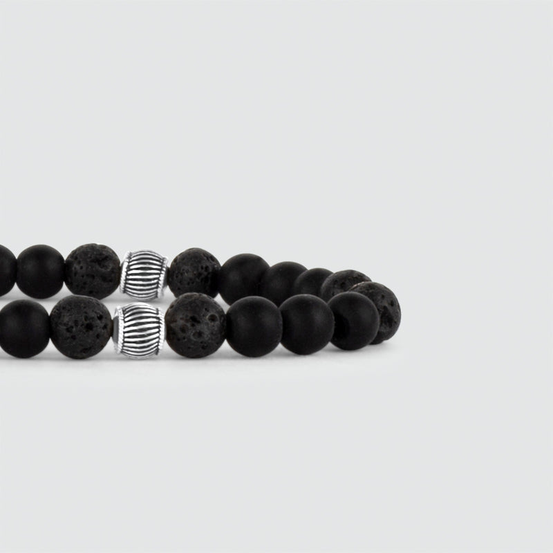 Een Kaliq zwarte onyx heren kralenarmband in 925 sterling zilver, getoond met lavasteen kralen.