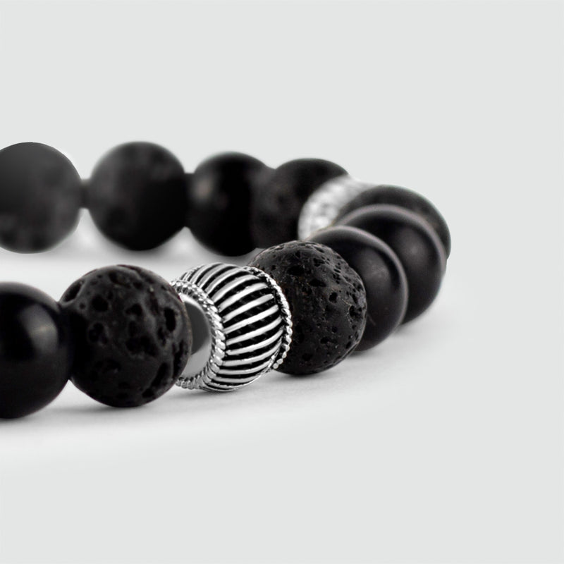A Kaliq adjustable onyx black beaded mens bracelet in silver, shows with lava stone beads.