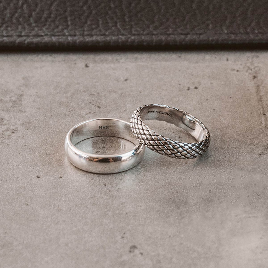 Two silver wedding rings rest atop a leather cover.