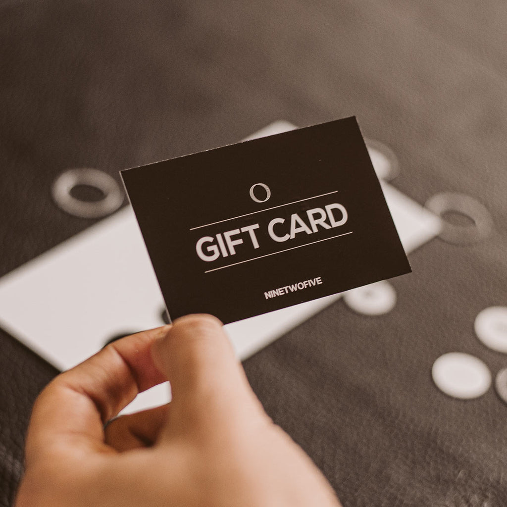 A person holding a gift card in front of buttons.