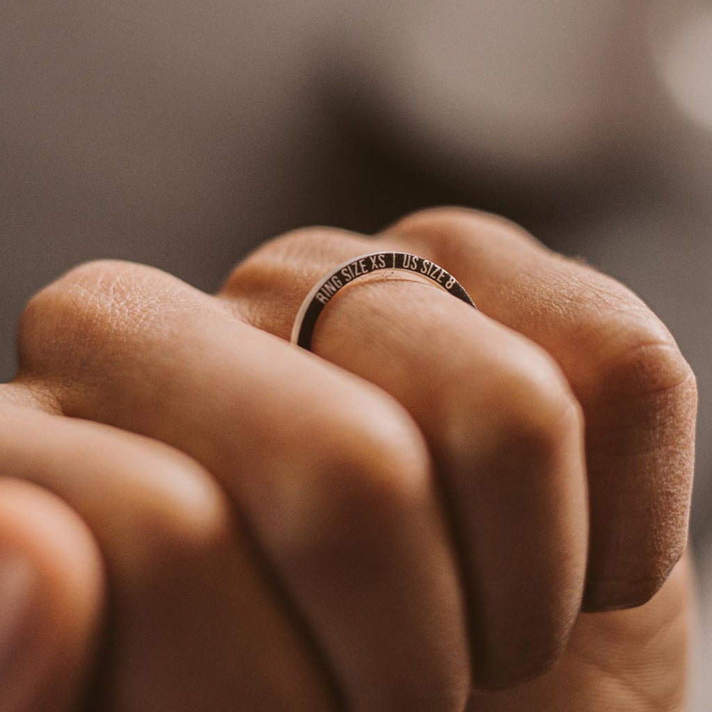 A person's hand holding a ring.