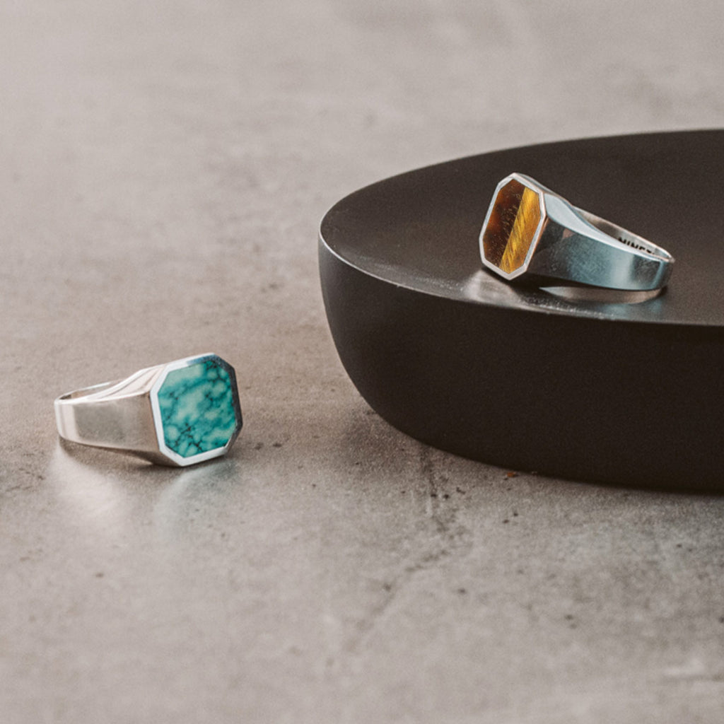 A signet ring with a silver band and a turquoise stone.